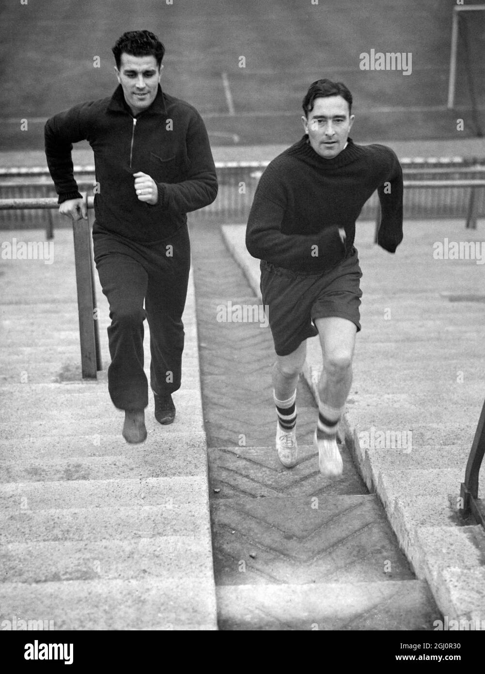 Denis Compton (rechts), der sich nun von der Operation am Knie erholt hat, führte eine Übung durch, die Tom Whitaker vorgeschlagen hatte, um seine schnelle Rückkehr zum Ligafußball zu gewährleisten. Mit ihm ist sein Bruder Leslie, im Arsenal-Stadion. Oktober 1947. Stockfoto