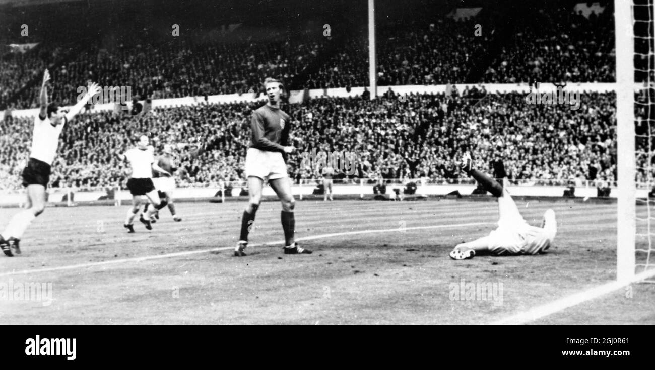 Westdeutschland steht im Finale der Fußball-Weltmeisterschaft 1966 an erster Stelle Helmut Haller (außer Schuss) führt an Gordon Banks vorbei und führt 1-0 an der Spitze. Der englische Jack Charlton steht ungläubig. 30. Juli 1966 Stockfoto