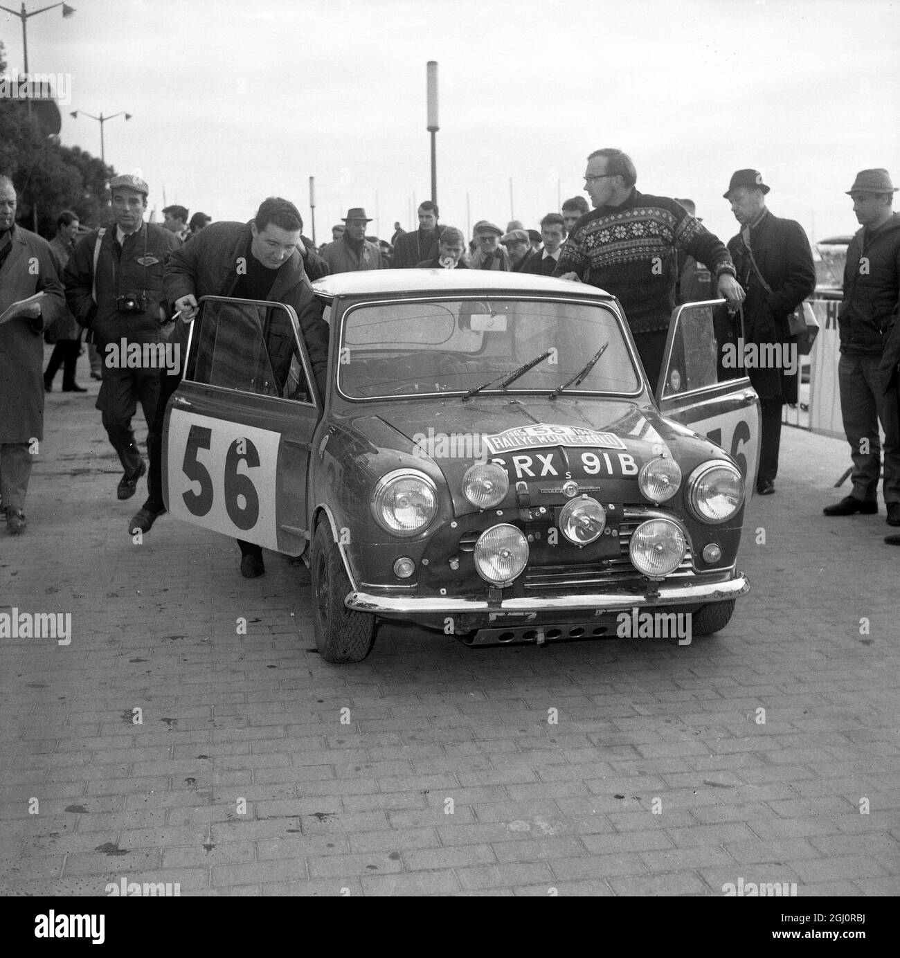 Monte Carlo, Monaco: Paddy Hopkirk, letztjähriger Sieger der Rallye Monte Carlo, und sein Beifahrer Henry Liddon kommen in Monte Carlo in ihrem BMC Cooper ''S'' während der Rallye 1965 am 19. Januar an. Sie mussten sich nach einem Zusammenbruch aus dem diesjährigen Ereignis zurückziehen. 21. Januar 1965 Stockfoto