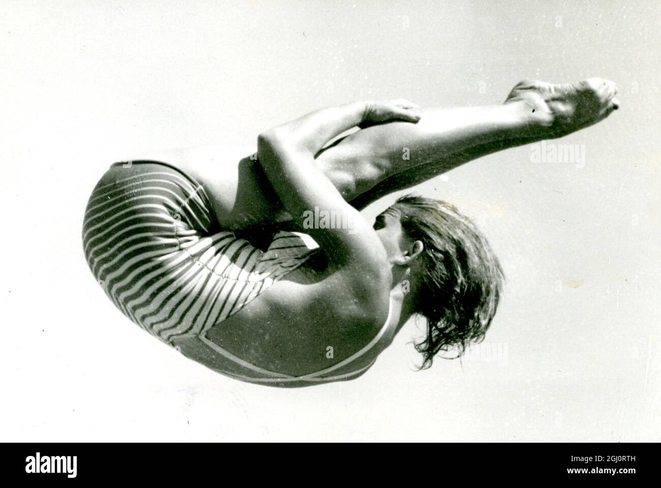 Die amerikanische Taucherin Patricia McCormick rollt sich während des Trainings für das olympische Tauchen im Olympic Pool hier in Helsinki, Finnland, eng und anmutig in der Luft. 29. Juli 1952 Stockfoto