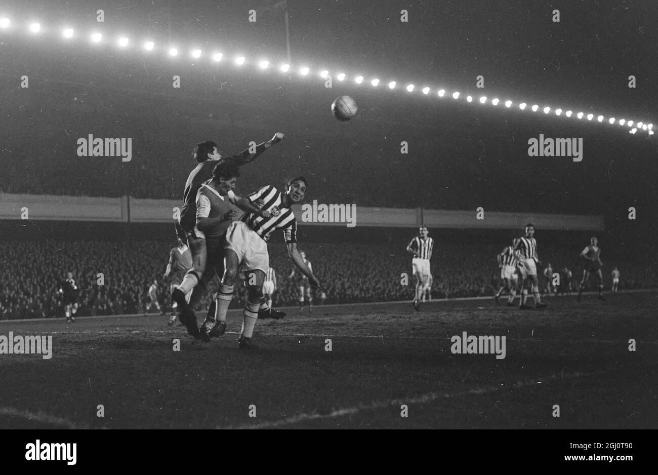 DAVE HOLLINS, DER TORWART VON BRIGHTON, LÖSCHT EINEN KOPFBALL VON SAWYER, DEM ROTHERHAM CENTER FORWARD, WÄHREND DER 4. F A CUP RUNDE ZWISCHEN BRIGHTON UND HOVE ALBION UND ROTHERHAM FUSSBALLSPIEL AM 8. FEBRUAR 1960 Stockfoto
