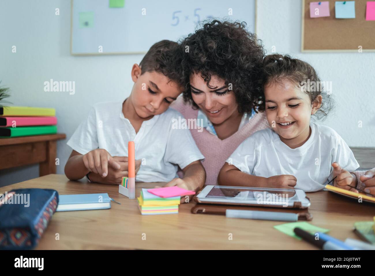 Lehrer mit Tablet mit Kindern in der Kindergartenschule - Fokus auf Mädchen Gesicht Stockfoto