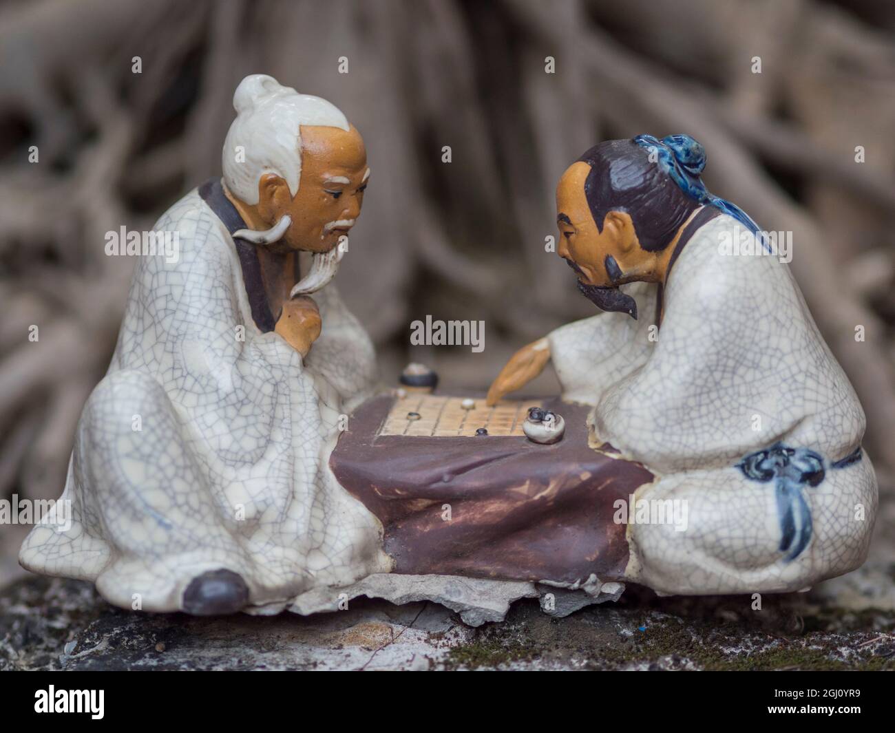 Vietnam, Hanoi. Tempel der Literatur, bemalte Keramik von 2 Männern, die traditionelles Spiel spielen. Stockfoto