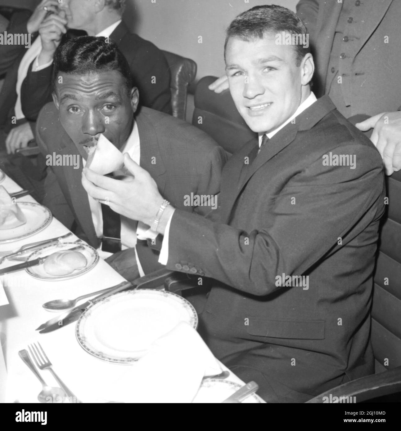 BRITAIN'S DAVE CHARNLEY GIBT DEM BOXMEISTER JOE BROWN AM 7. APRIL 1961 EINE MELONE Stockfoto