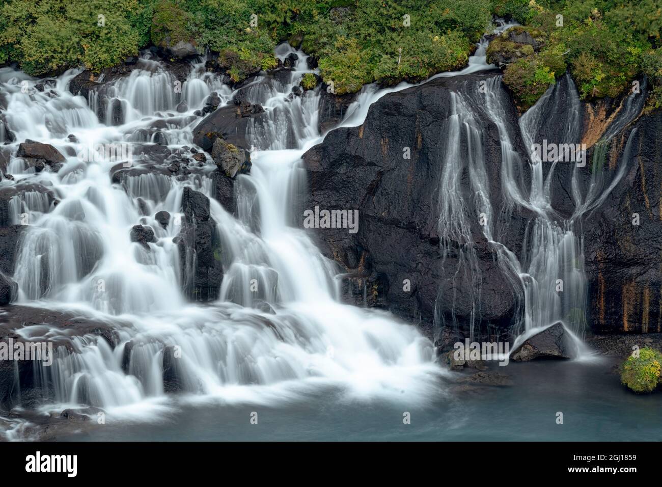 Island, Hraunfossar. Aus der Lava tauchen kleine Kaskaden auf, die über eine halbe Meile in den Hvita River münden. Stockfoto