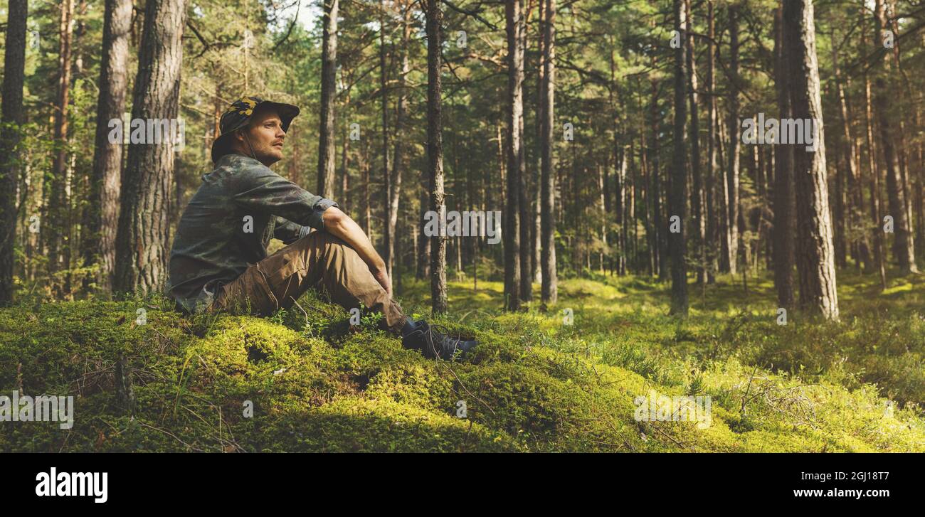 Waldranger oder Förster sitzen auf dem Hügel und beobachten das Gebiet. Raum kopieren Stockfoto