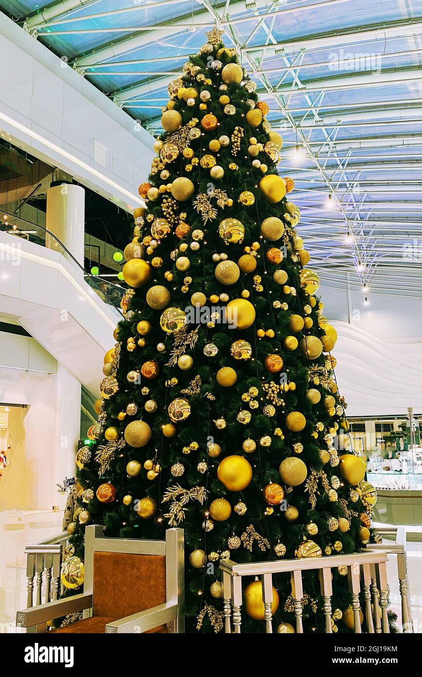 Weihnachtsbaum im europäischen Einkaufszentrum. Neujahr und Urlaub im Winter. Goldene Weihnachtsdekoration. Stockfoto