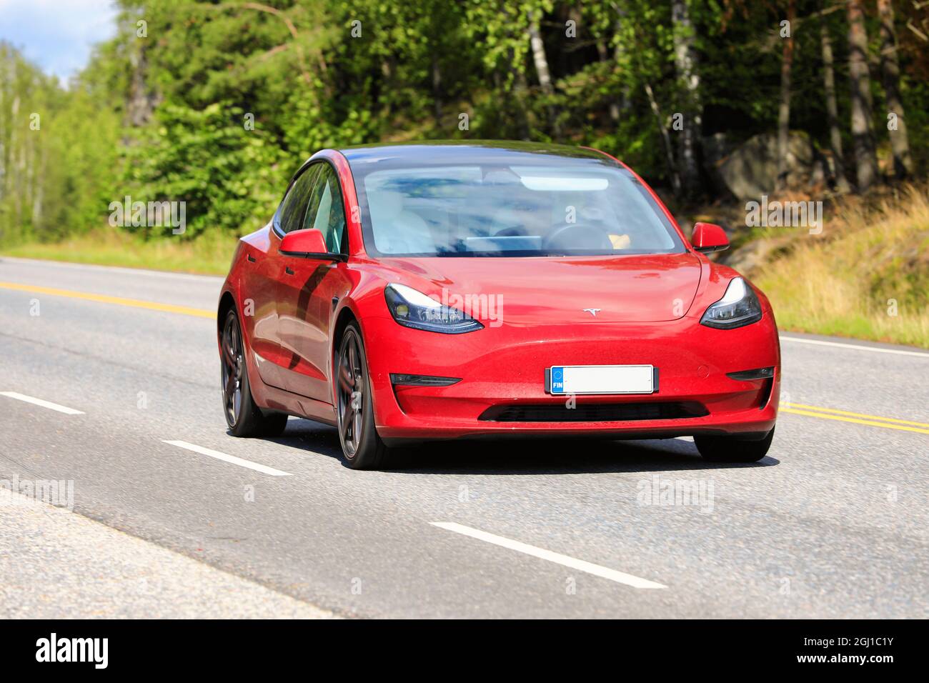 Rotes Tesla Modell 3 Elektroauto auf der Straße. Das Modell 3 verfügt über die volle Selbstfahrfunktion, die optional aktiviert werden kann. Salo, Finnland. 13. August 2021. Stockfoto