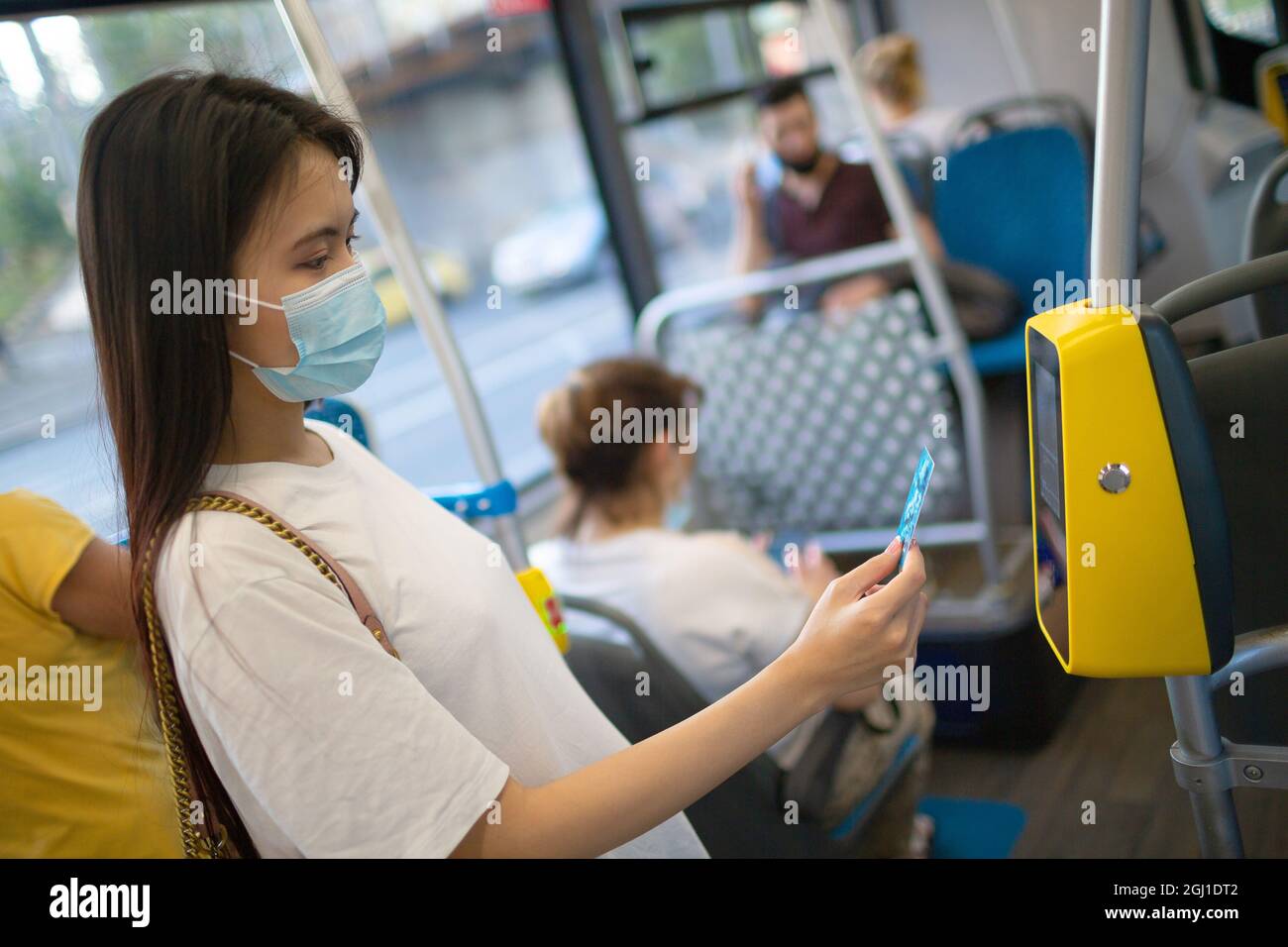 Asiatische Frau, die mit Plastikkarte für die öffentlichen Verkehrsmittel in Bus, Straßenbahn oder U-Bahn-Station ohne Konzetszahlung bezahlt Stockfoto