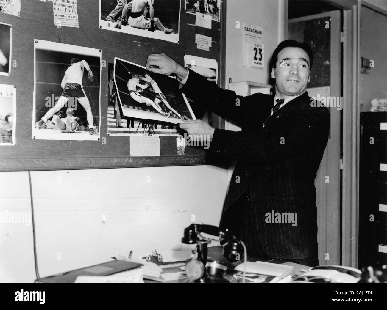 Marcel Cerdan war ein französischer Boxweltmeister. Hier zeigt er Fotos von früheren Kämpfen. Stockfoto