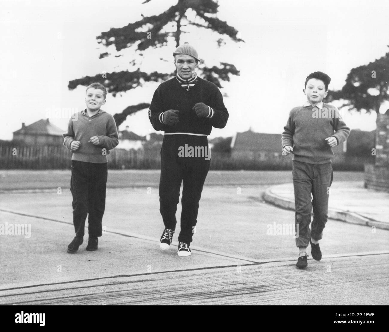 Dave Charnley trainiert vor dem Kampf gegen Joe Brown. Zwei benachbarte Kinder-Unterstützer schließen sich ihm an, Terry Lidsey (links) und John Hazelgrove , beide 10 Jahre alt. April 1961 Stockfoto