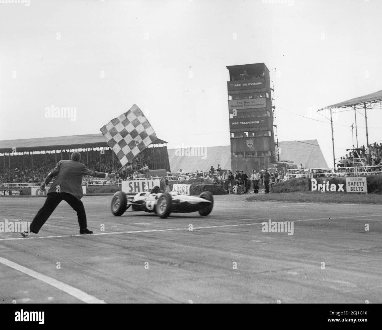 Jim Clark : 1936 - 1968 , britischer Formel-1-Rennfahrer aus Schottland , gezeigt in Silverstone, England, unter der Zielflagge, um den 16. Britischen Grand Prix 1965 am 20. Juli 1963 zu gewinnen Stockfoto