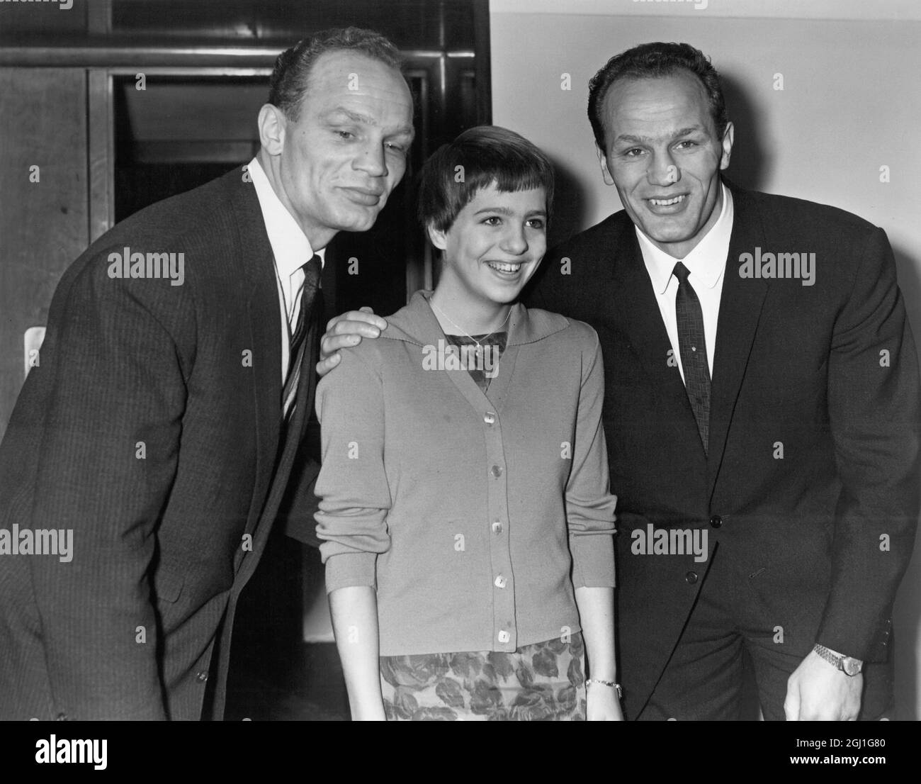 Linda Ludgrove, Gewinnerin von zwei Goldmedaillen im Schwimmen bei den Empire Games in Australien, mit den Cooper Zwillingen, Jim (links) und Henry Cooper, dem britischen Schwergewichtsmeister. 8. Januar 1963 Stockfoto