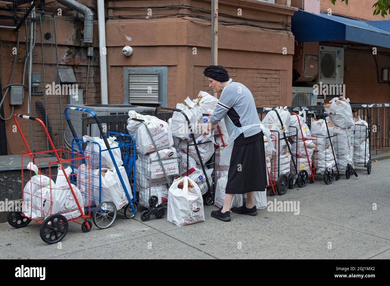 Ein Freiwilliger der orthodoxen jüdischen Gruppe von Satmar bereitet Lebensmittelpakete zu, die an Bedürftige und Menschen in Krankenhäusern, die eine koschere Mahlzeit benötigen, verteilt werden. Stockfoto