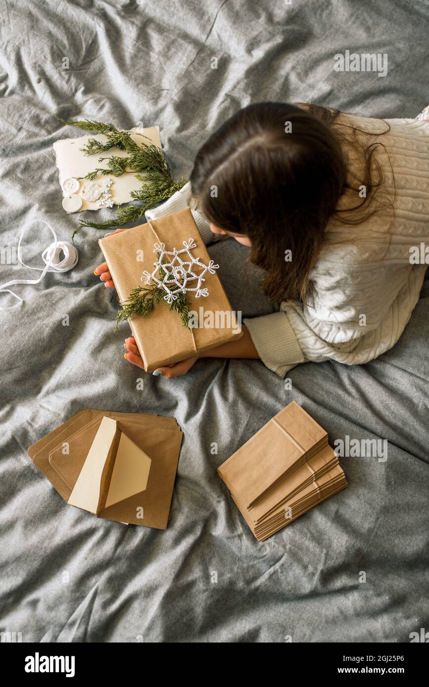 Mädchen Verpackung Geschenke mit Weihnachtsdekoration.Geschenk in einer Box, ein Brief in einem Handwerk Umschlag. Stockfoto