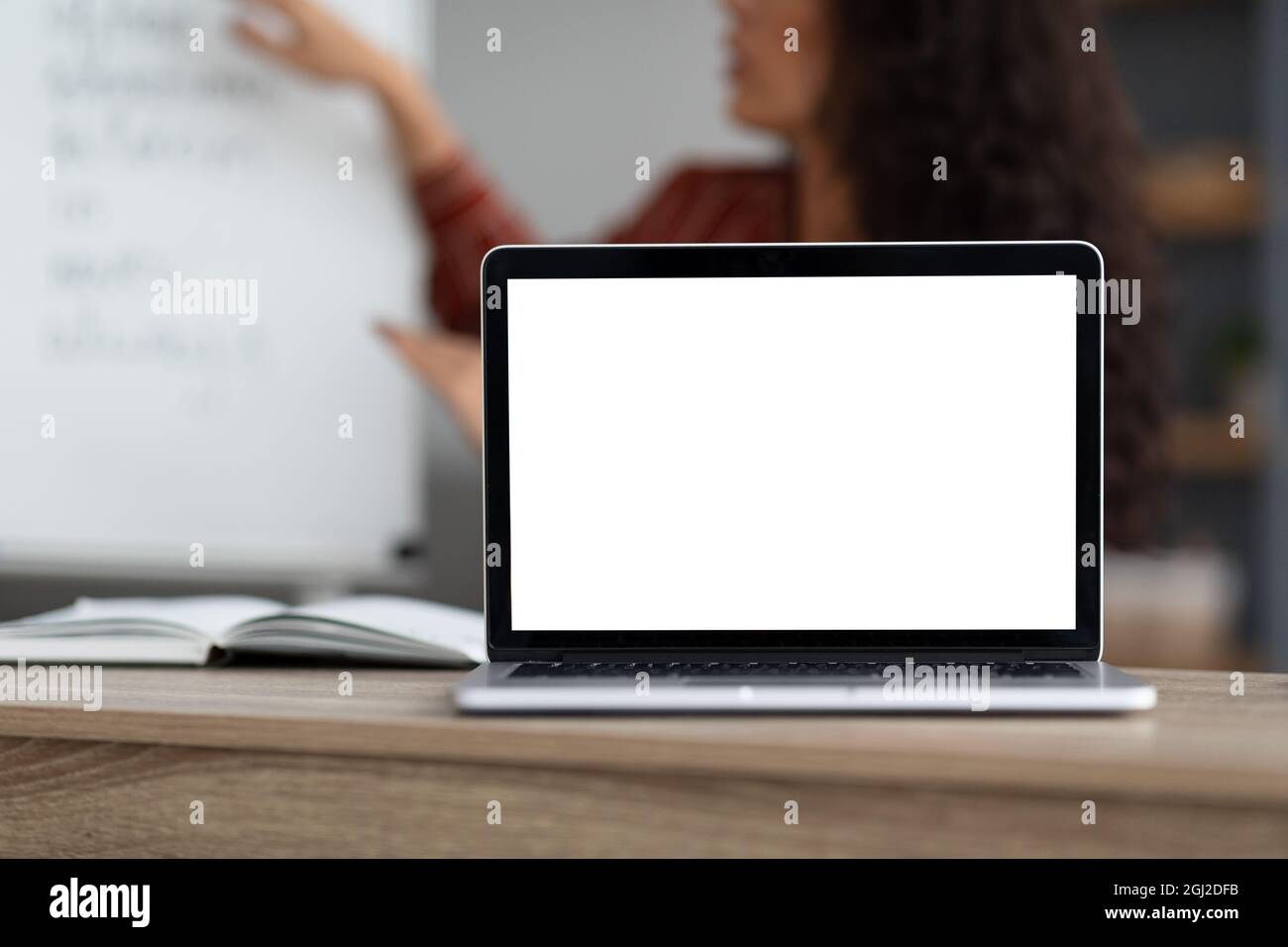 E-Learning-Kurs, Fernschulung. Selektiver Fokus auf leeren weißen Laptop-Bildschirm auf dem Tisch, Modell. Weibliche Lehrerin schießen Video-Vortrag mit compu Stockfoto