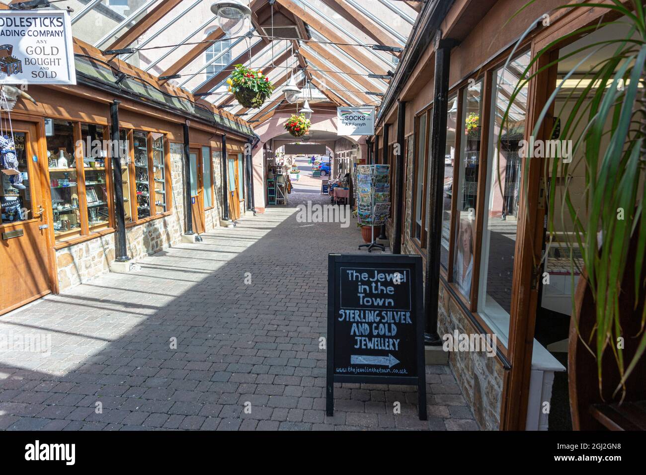 Interieur des Great Torrington Pannier Market, Geschäfte und Glasdach Detail mit Blick auf den Hauptstadteingang und Torrington Square Stockfoto Interieur des Great Torrington Pannier Market, Geschäfte und Glasdach Detail mit Blick auf den Hauptstadteingang und Torrington Square Stockfoto