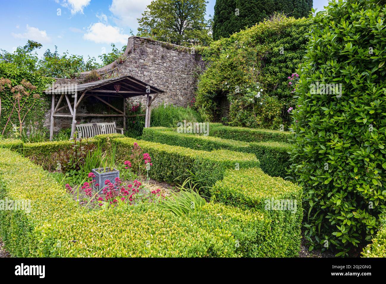 Ruhe und Frieden: Schlosshügel-Gartenlandschaft mit schattigem Sitz. Bild von einem der ruhigen Gartengebiete in der Great Torrington Community Area. Stockfoto