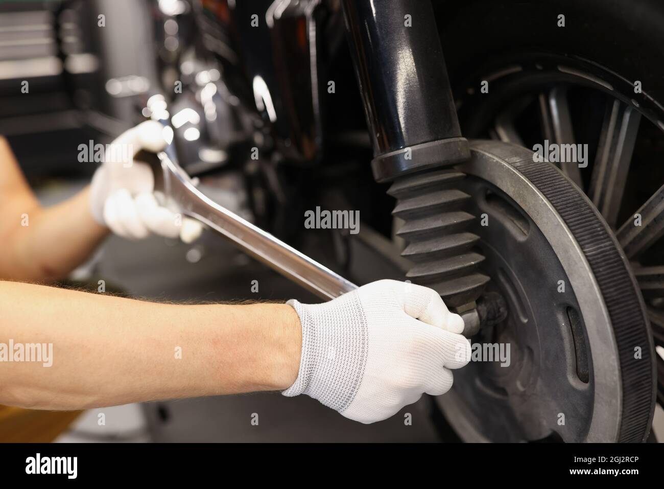 Mechanische Hand verwenden Schlüssel und Düse Motorrad Stoßdämpfer einstellen Stockfoto