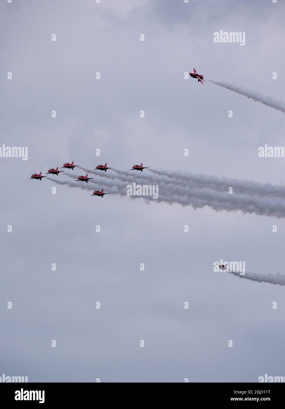 Rote Pfeile Luftbildteam in enger Formation mit einem Jet über der Hauptgruppe Stockfoto