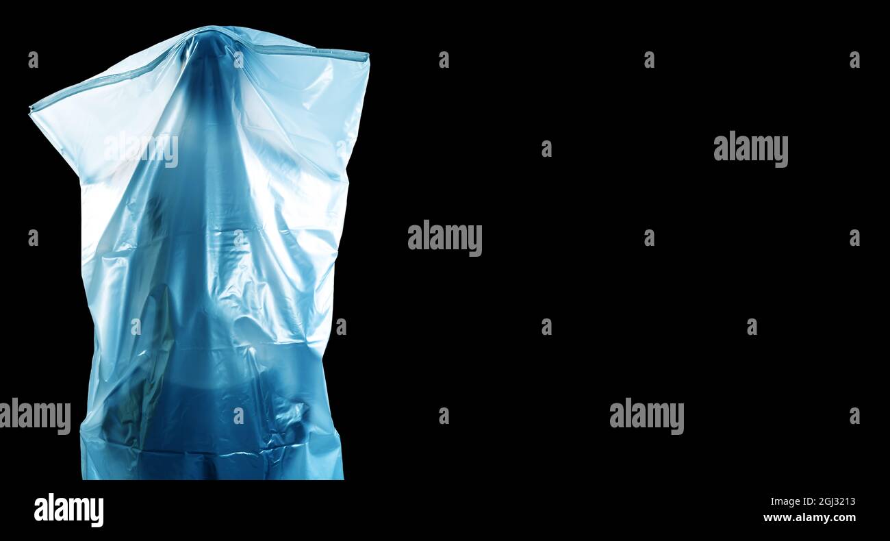 Ein Mann, der wie ein Geist mit einem weißen Grabtuch bedeckt ist, zeigt Entsetzen isoliert auf schwarzem Hintergrund Stockfoto