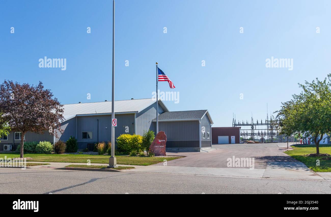 LUVERNE, MN, USA-21. AUGUST 2021: Luvernes Büros für öffentliche Arbeiten, die Gebäude, Felsschild und Umspannwerk dahinter zeigen. Stockfoto