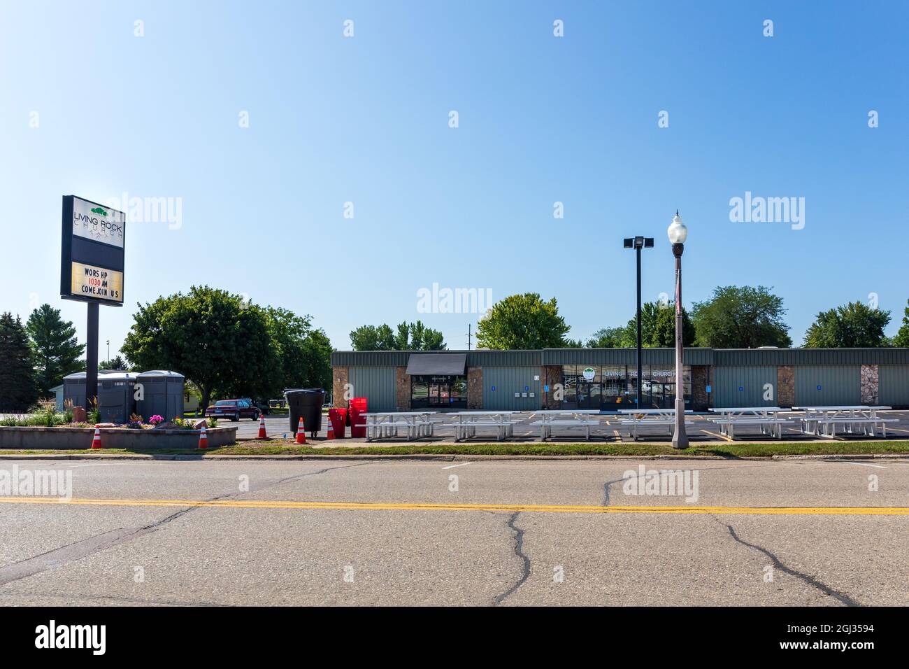 LUVERNE, MN, USA-21 AUGUST 2021: Die Living Rock Church in der Main Street zeigt Gebäude, Schilder, tragbare Toiletten und Picknicktische auf dem Parkplatz. Stockfoto