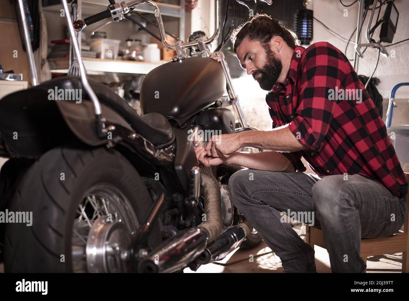 Junger Mann repariert ein Motorrad Stockfoto