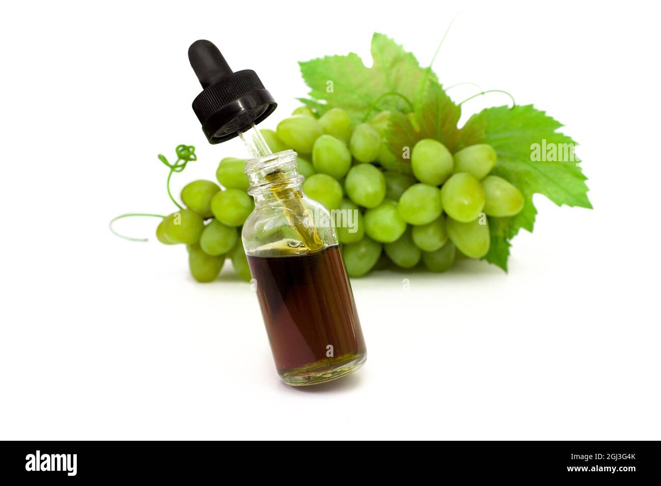Flasche mit Pipette mit grünem Traubenkernöl auf weißem Hintergrund.Copy Space, flach liegend, Ansicht von oben. Stockfoto