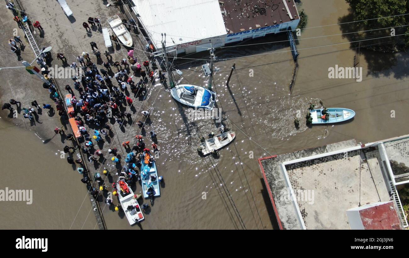 Tula, Mexiko. September 2021. Menschen stehen umgeben von Wassermassen und werden nach starken Regenfällen von kleinen Booten evakuiert. Am 07.09.2021 hatten drei Flüsse in der Region ihre Ufer geplatzt. Hunderte von Menschen mussten sich im Morgengrauen in Notunterkünften unterbringen lassen. Quelle: Fabian Reyna/dpa/Alamy Live News Stockfoto