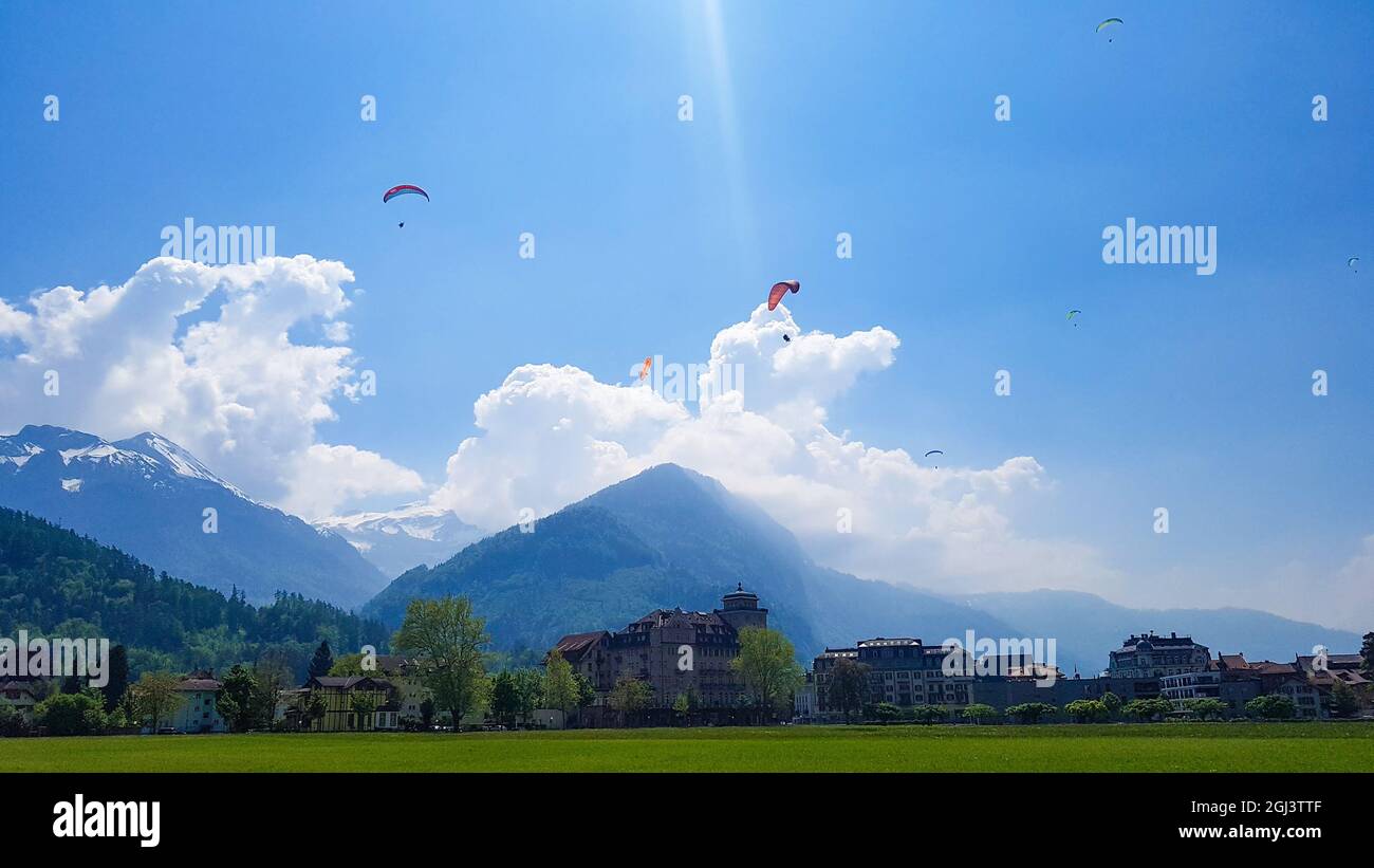 Strahlend blauer Himmel gefüllt mit bunten Gleitschirmen in Interlaken, Schweiz Stockfoto