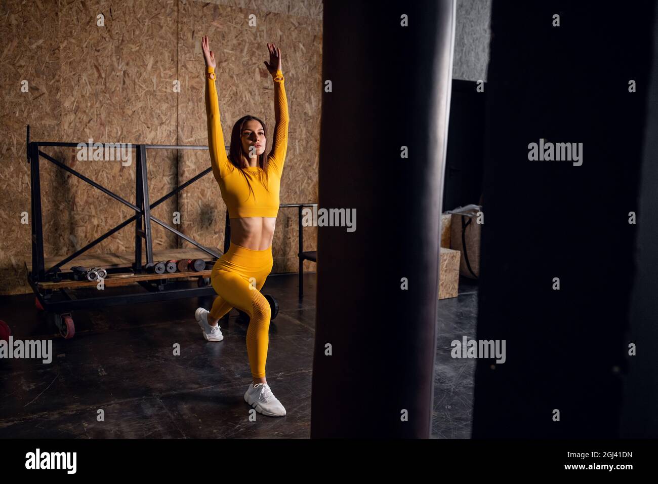Junge Yogi-Frau, die Yoga-Konzept praktiziert, eine einbeinige King Pigeon-Übung macht, trainiert, Sportkleidung trägt, Loft-Studio Hintergrund Stockfoto