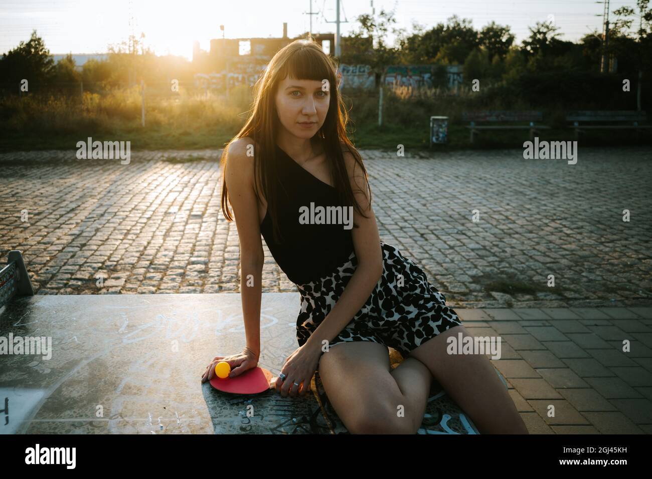 Stilvolle kaukasische Frau, die sich auf dem Tischtennistisch lehnt Stockfoto