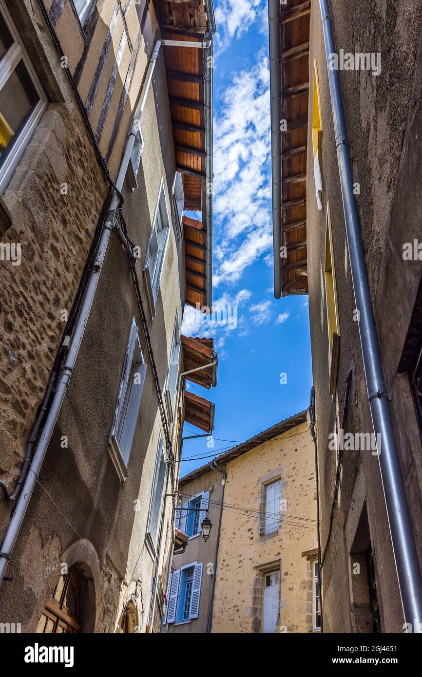 Alte Häuser und Dächer schließen sich in einer schmalen Straße in Saint-Léonard-de-Noblat, Haute-Vienne (87), Frankreich. Stockfoto