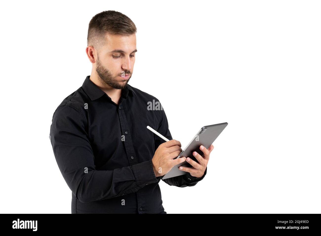 Junger Mann mit einem schwarzen Hemd, der Notizen auf einer grauen Tafel auf weißem Hintergrund gemacht hat Stockfoto