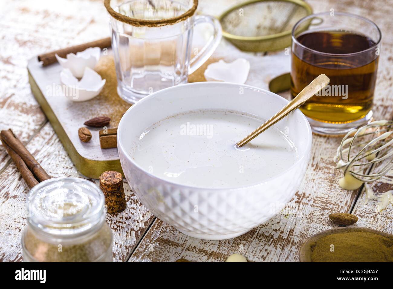 Zutaten für Weihnachtsrezepte, wie man weihnachtlichen Eierlikör mit Eiern, Likör, Zimt und Kastanien zubereitet Stockfoto