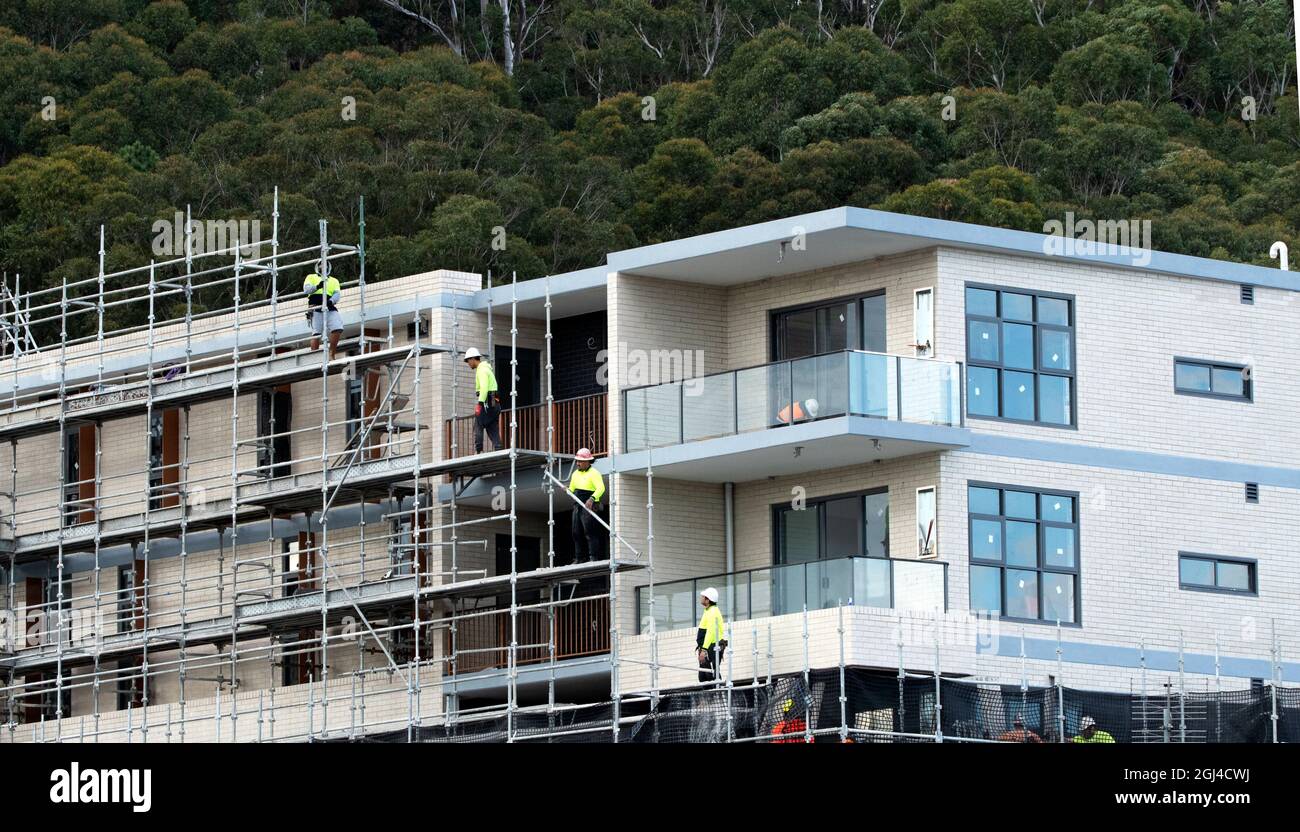 Gosford, NSW, Australien - 15. Juli 2021: Arbeiter demontieren Sicherheitsnetze und Gerüste in den nun fertiggestellten oberen Stockwerken des neuen sozialen Wohnungsbaus bei Stockfoto