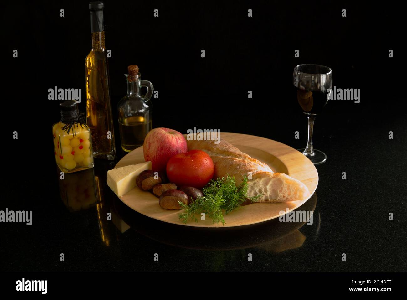 Teller mit Pflugmännern Mittagessen mit einem Glas Wein und Flaschen Olivenöl und Oliven Stockfoto