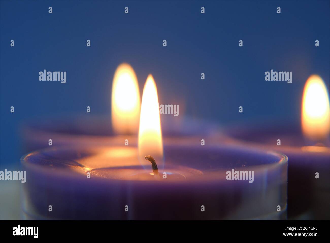 Brennende Kerzen.Religion Symbol. Kerzen Hintergrund.Blaue Kerzen auf blauem Hintergrund Stockfoto