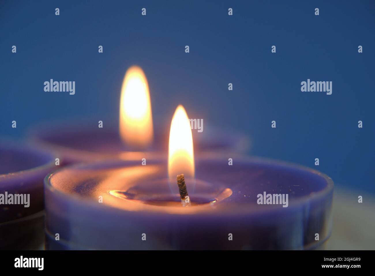 Kerzenflamme.Set von blauen Kerzen im Dunkeln.Religion Symbol. Kerzen Hintergrund.Blaue Kerzen auf blauem Hintergrund Stockfoto