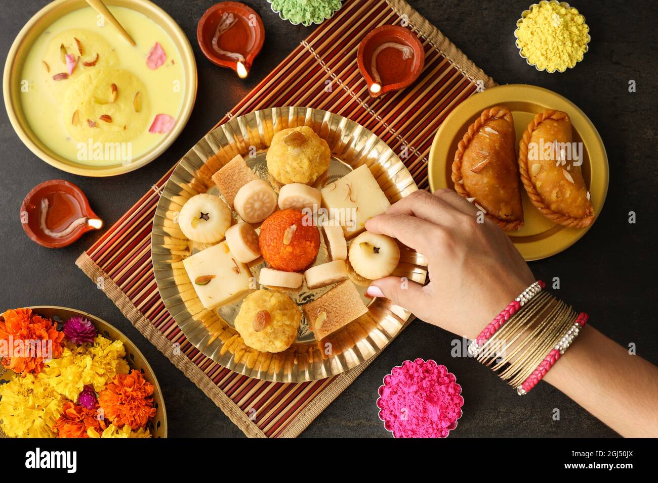 Indische Frau nimmt Diwali Süßigkeiten Gujiya peda barfi Indische süße Dessert mithai Festival Gericht Dussehra Holi ganesh chaturthi RAM navami Durga pooja Stockfoto