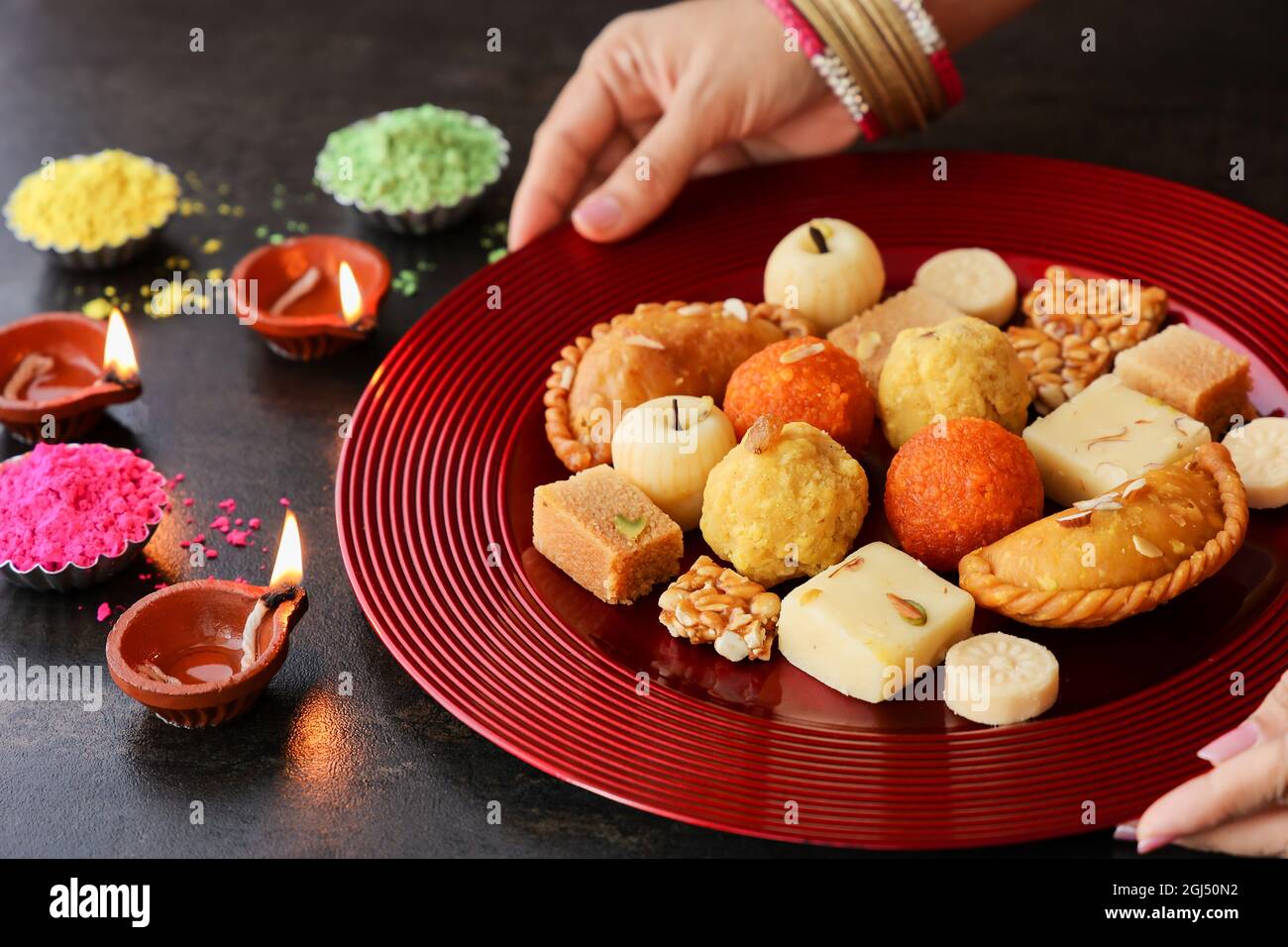 Indische Frau nimmt Diwali Süßigkeiten Gujiya peda barfi Indische süße Dessert mithai Festival Gericht Dussehra Holi ganesh chaturthi RAM navami Durga pooja Stockfoto
