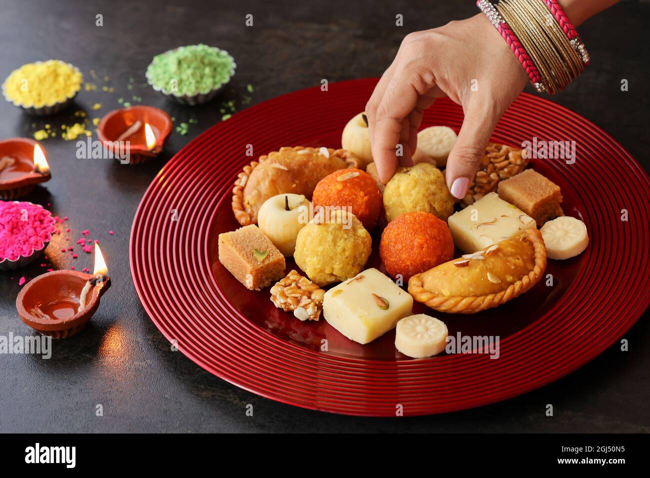 Indische Frau nimmt Diwali Süßigkeiten Gujiya peda barfi Indische süße Dessert mithai Festival Gericht Dussehra Holi ganesh chaturthi RAM navami Durga pooja Stockfoto