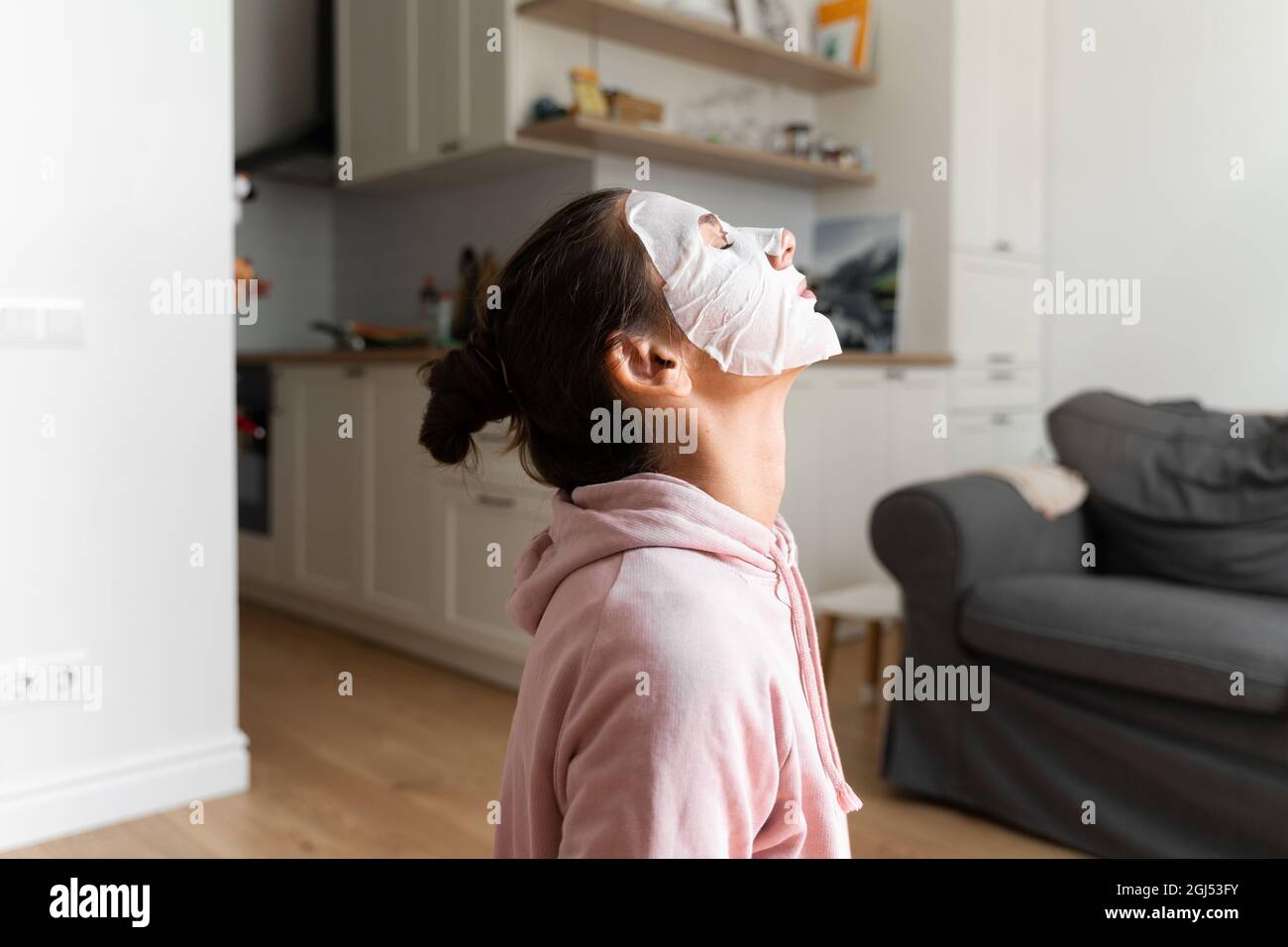 Junge Frau mit Schönheitsmaske zu Hause. Wellness-Konzept. Entspannung zu Hause für junge Mutter. Schnelle Gesichtsmaske für Home Spa. Stockfoto