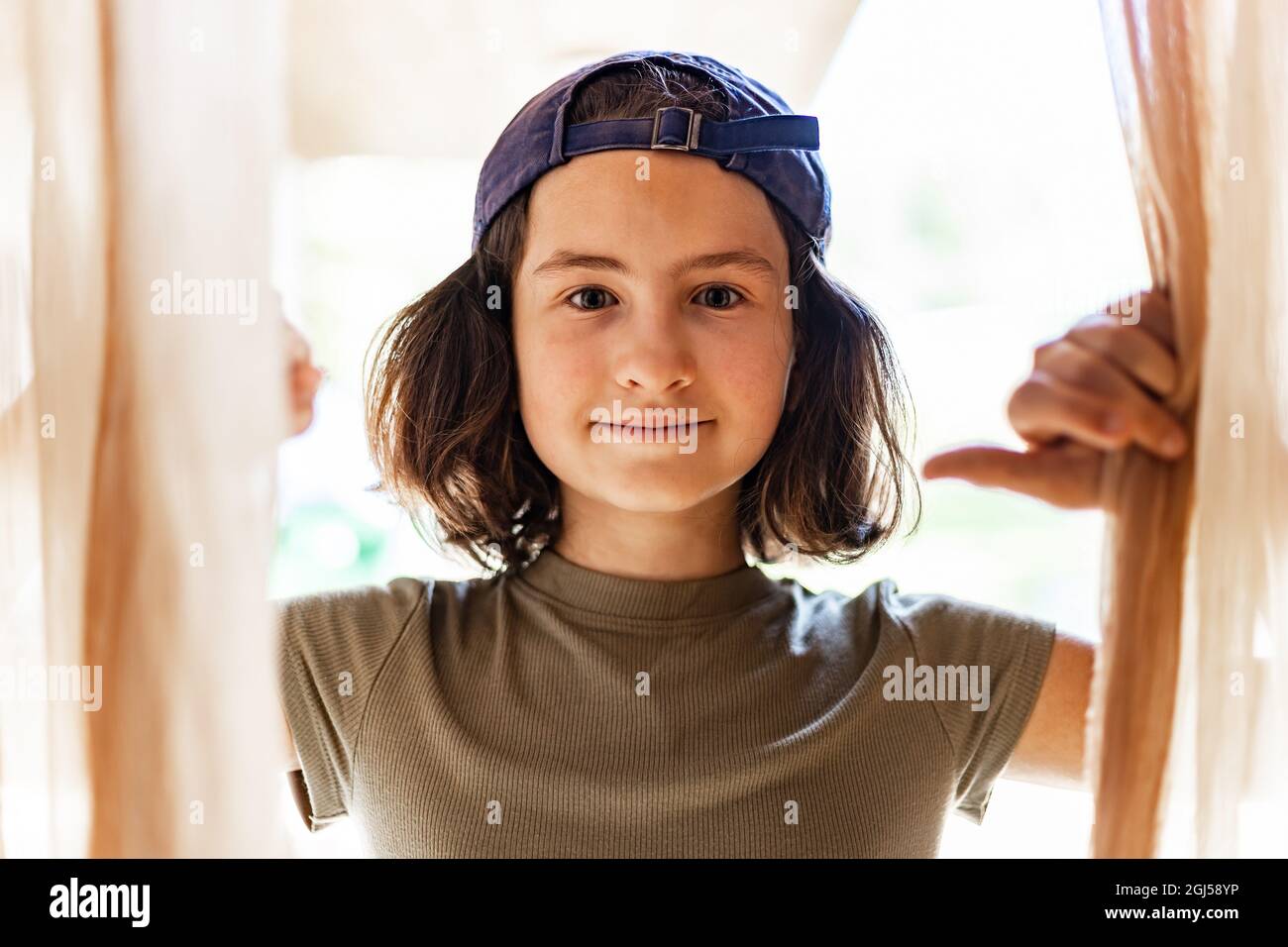 Sommerportrait eines jungen hübschen glücklichen Mädchens in einer gedrehten Baseballmütze. Fröhlich lächelnd Teenager Brünette Mädchen. Nahaufnahme. Lifestyle-Fotografie. Hoki Stockfoto