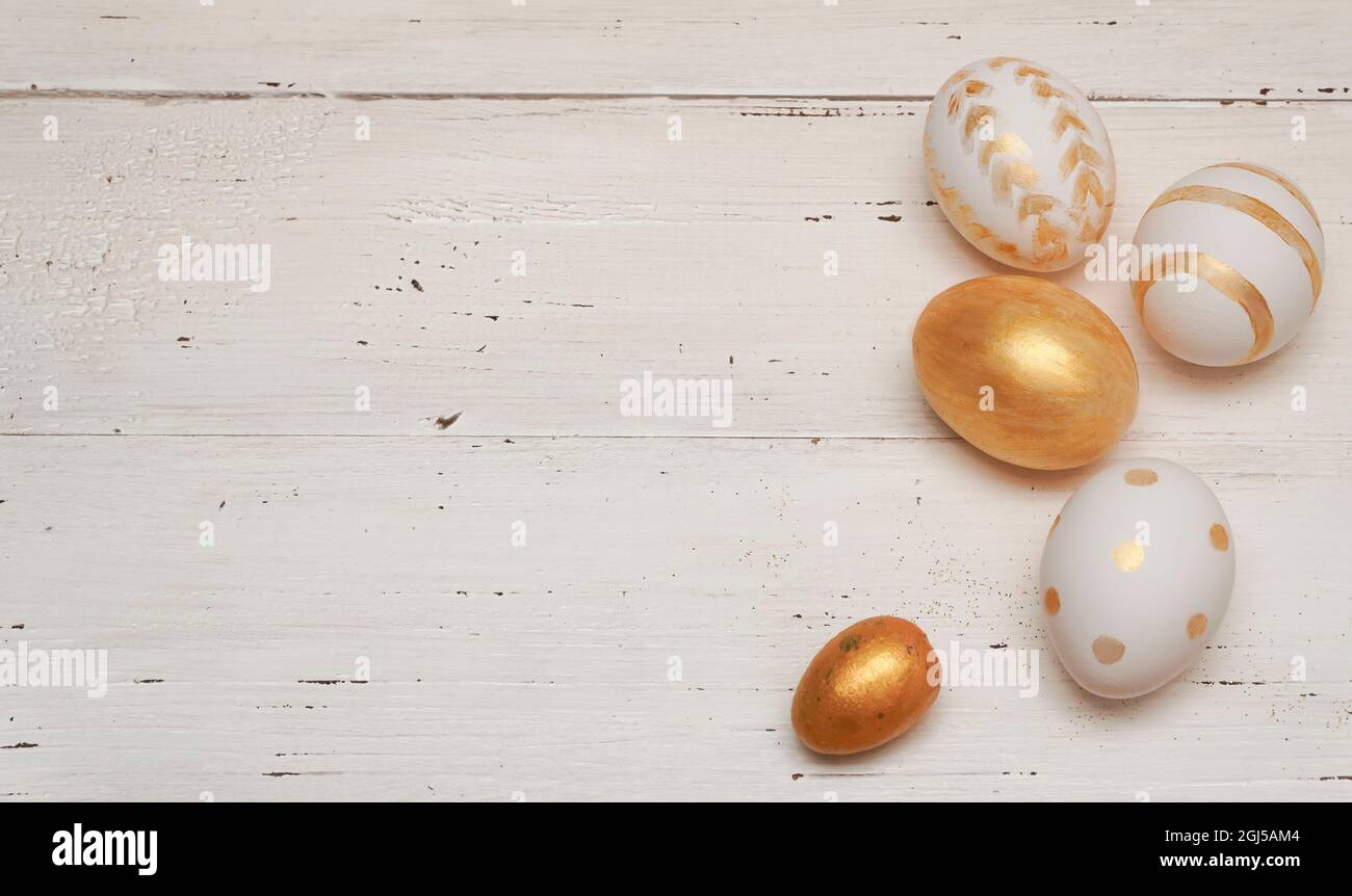 Goldene Ostereier auf rustikalem alten Holzhintergrund. Trendige, flache Lay-Komposition zu Ostern. Platz für Text kopieren. Minimales Osterkonzept. Stockfoto