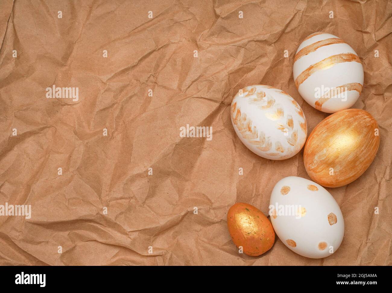 Goldene Ostereier auf Bastelpapier-Hintergrund. Trendige, flache Lay-Komposition zu Ostern. Platz für Text kopieren. Minimales Osterkonzept. Alles gute zum Ostertag greeti Stockfoto