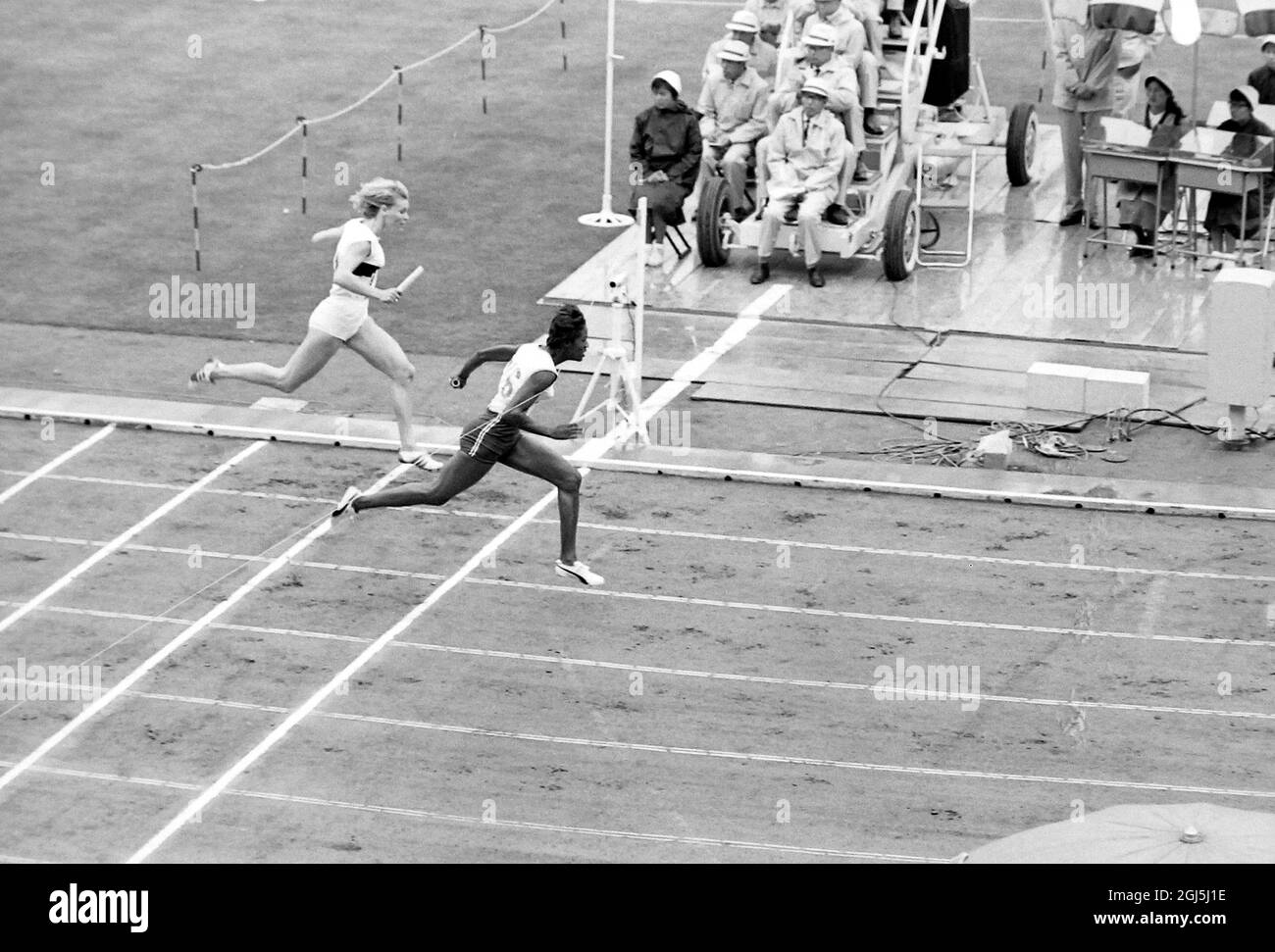 OLYMPISCHE SPIELE, OLYMPISCHE SPORTSPIELE - XVIII. OLYMPIADE IN TOKIO, JAPAN - RUNNING OLYMPICS WOMEN 4X100 US MEMBER CROSSES LINE WIN HEAT ; 21. OKTOBER 1964 Stockfoto