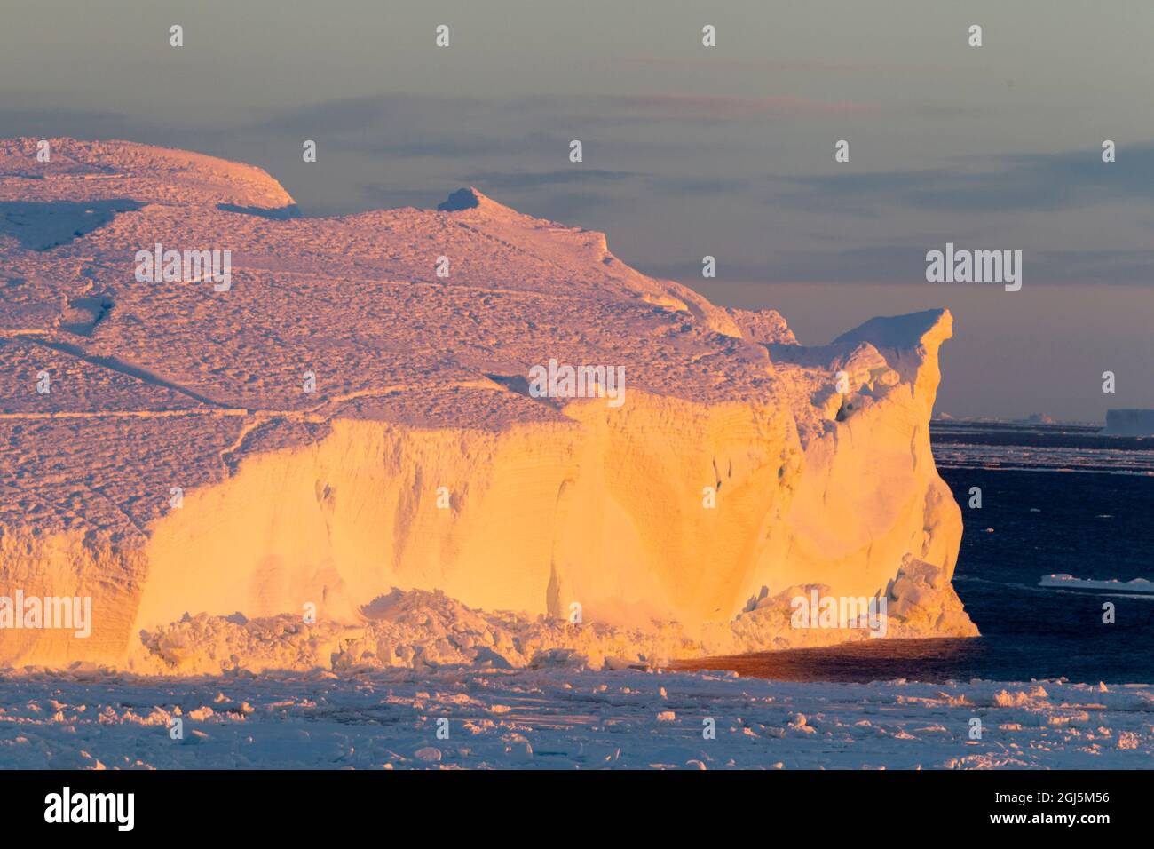Antarktis, Snow Hill. Das Licht des frühen Morgens reflektiert vom Eis mit einem orangefarbenen Leuchten. Stockfoto