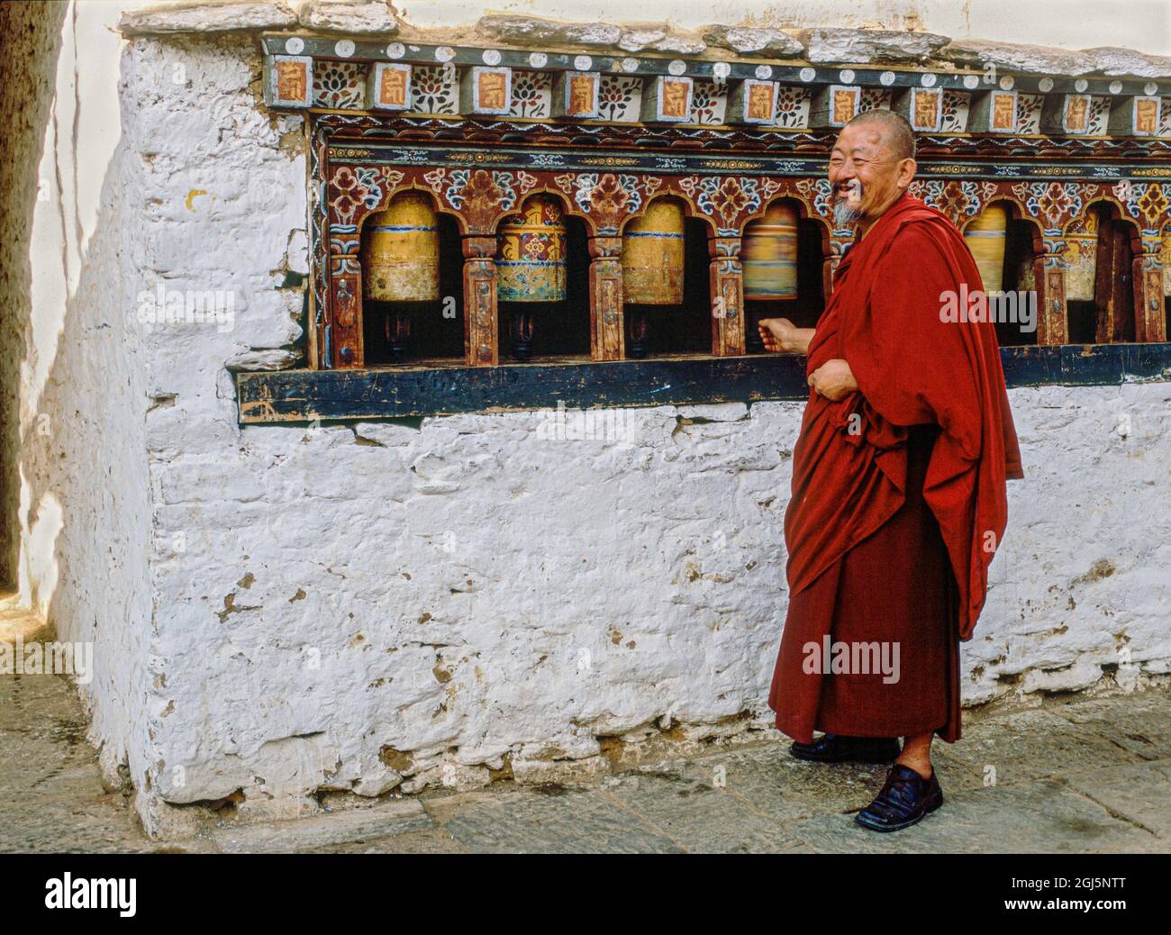 Ein Inhalt Bhutanesischer Mönch dreht Gebetsrad, Bhutan Stockfoto